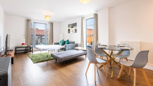 A modern apartment with a dining area, sofa, and a view of the city. - Near LEGOLAND, Heathrow and Historic Windsor (Berkshire)
