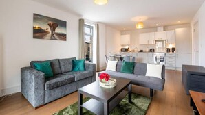 A modern living room with a grey sofa, a coffee table, and a painting on the wall. - Near LEGOLAND, Heathrow and Historic Windsor (Berkshire)