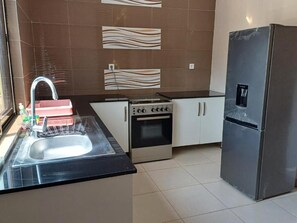Una cocina equipada con fregadero, estufa, horno y refrigerador.