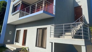 Un edifici modern de dos pisos amb un balcó, una escala i una porta.