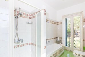 Un baño con ducha, bañera e inodoro.