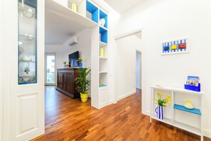 Ein modernes Interieur mit Holzböden, weißen Wänden und eingebauten Regalen mit Dekorationselementen.