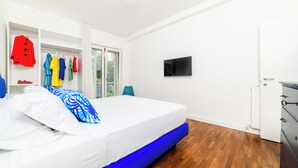 Une chambre à coucher avec un lit, une armoire, un téléviseur et un radiateur.