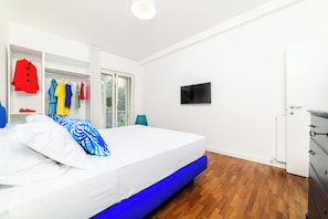 Ein Schlafzimmer mit einem Bett, einem Kleiderschrank, einem Fernseher und einer Heizung.