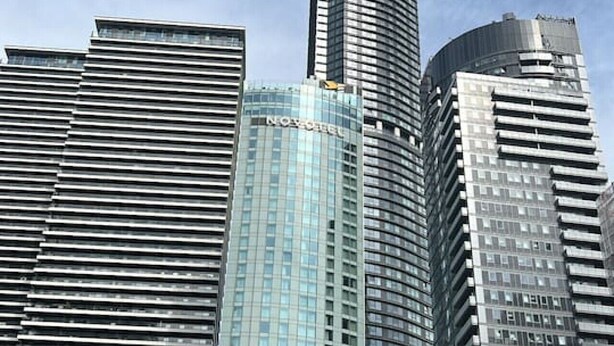 A high-rise building with a curved facade and a glass exterior. - Canary Wharf 2BR | Skyline View + Work Ready (Greater London)