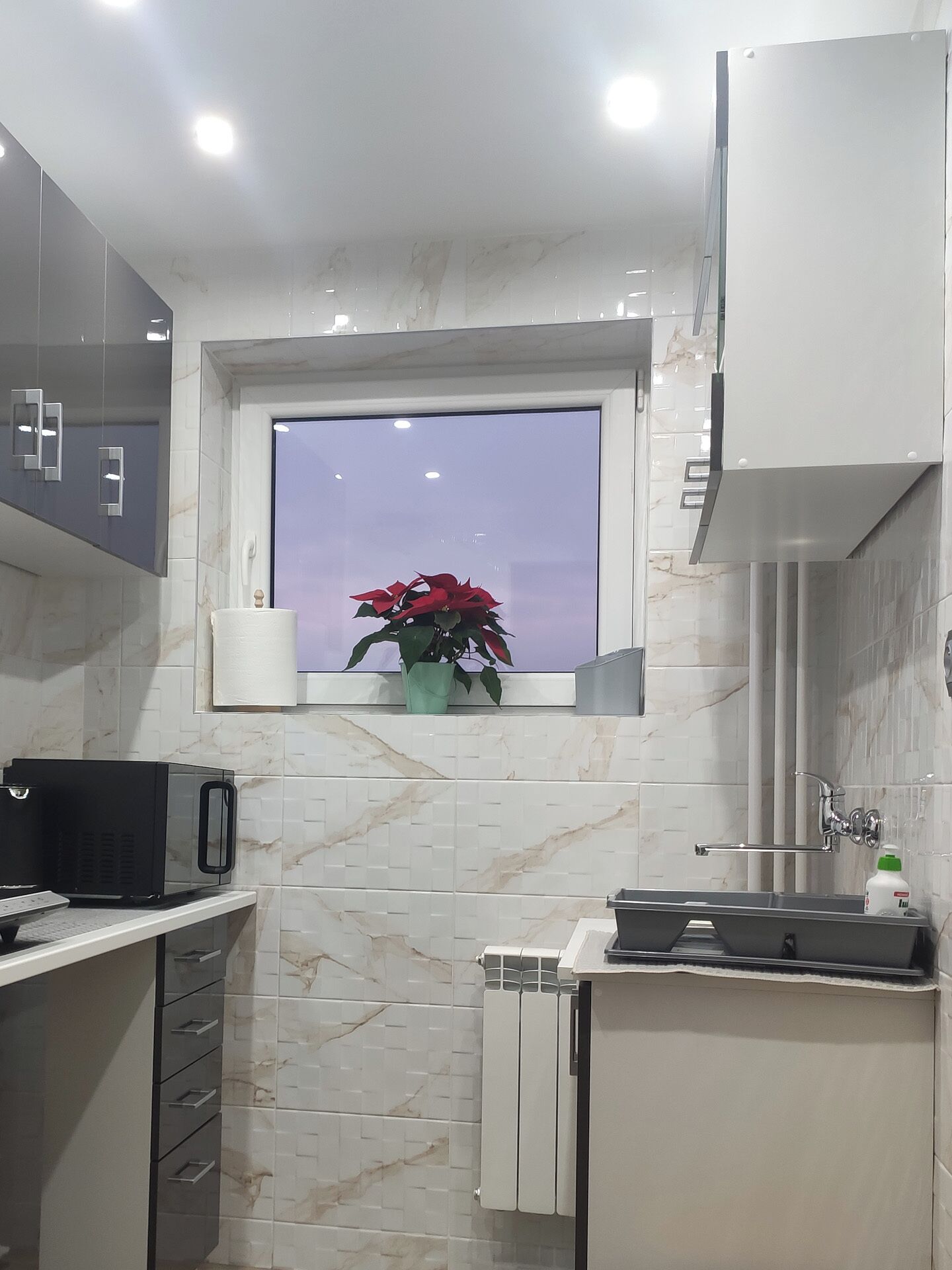 Eine moderne Küche mit Fenster, Heizkörper und Spüle.