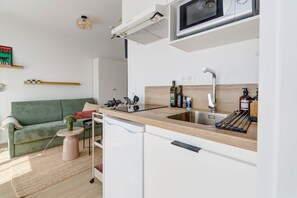 A compact kitchen with a microwave, sink, and wooden countertop. - Studio La Factory - Avec ventilateur (Reims)
