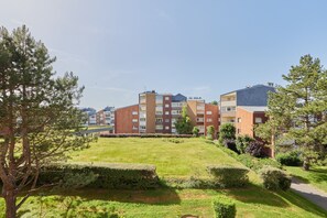 A residential building complex with multiple apartment buildings, a well-maintained grassy area, and mature trees. - A l'abri côtier - Appt avec balcon proche plage (Cabourg)