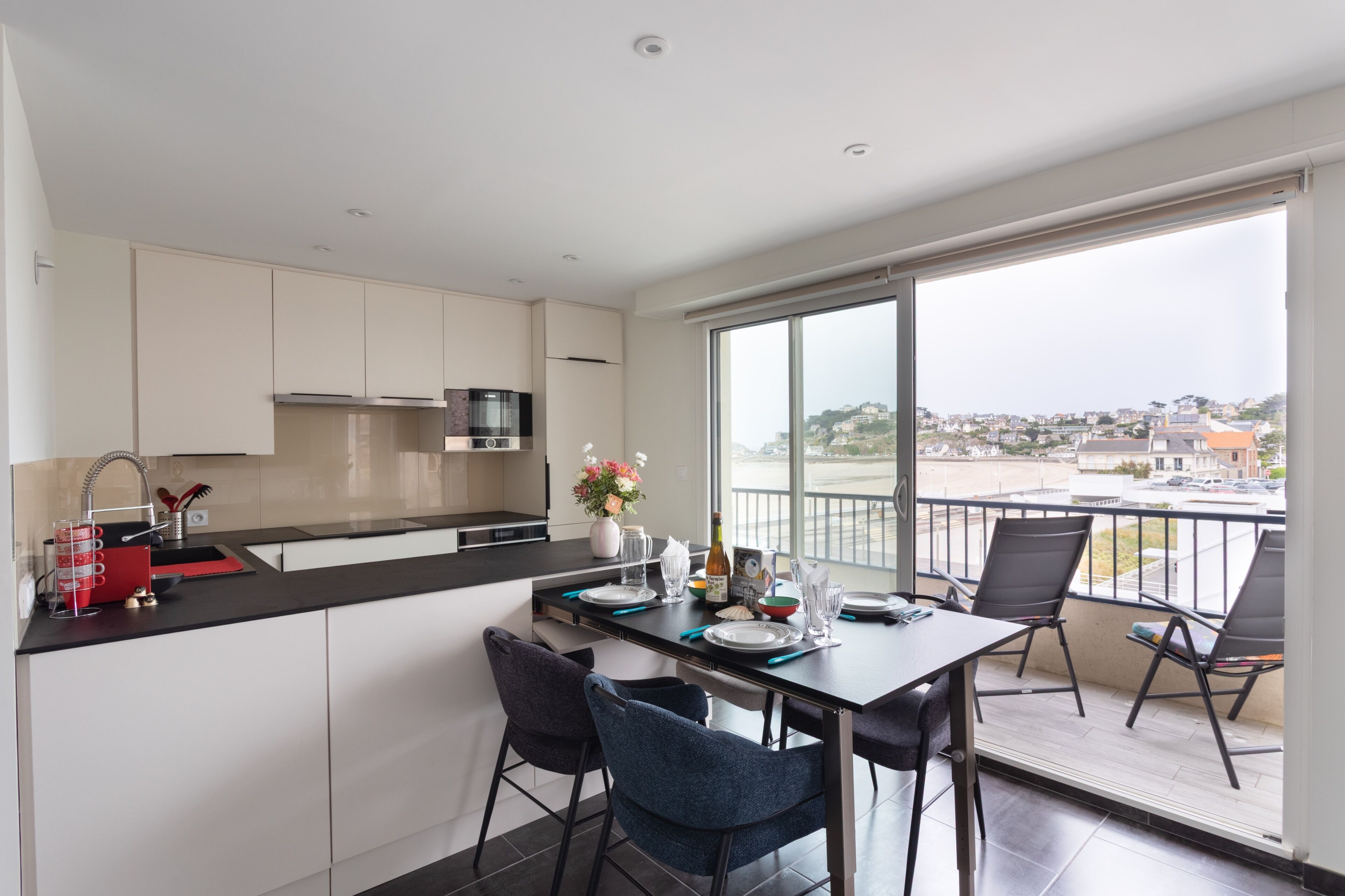 Una cocina moderna con comedor, ventanas amplias y vistas a la ciudad.