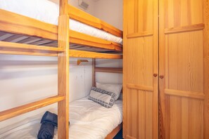 A bunk bed room with wooden headboards and a wardrobe. - La Fontaine du Corbeau et Grangettes (Huez)