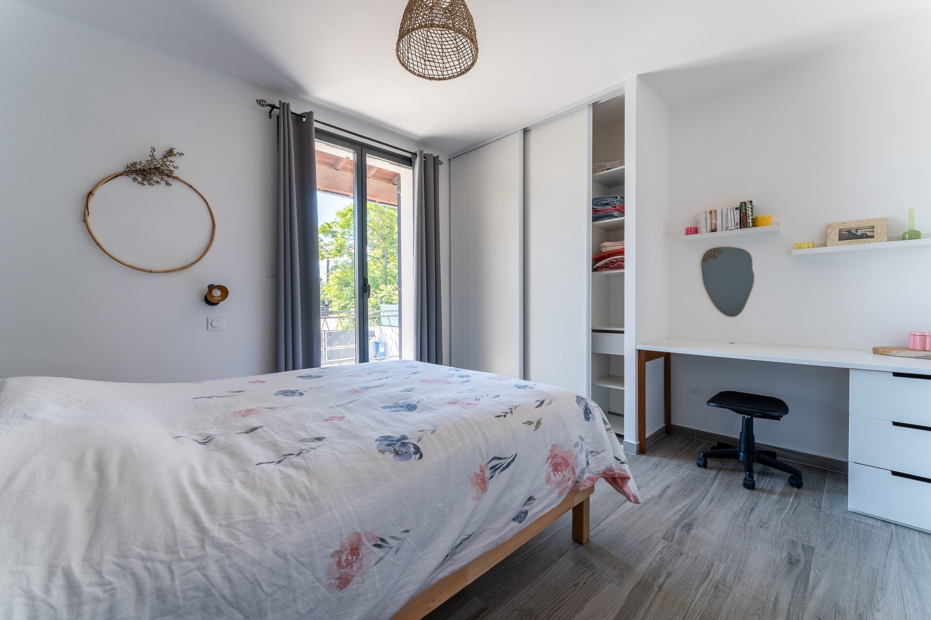 A bedroom with a bed, a desk, and a wardrobe.