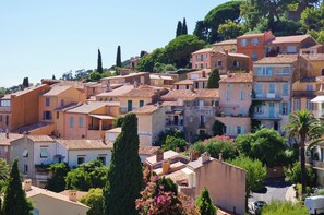 A hillside residential area with terracotta-roofed buildings, lush greenery, and a clear sky. - Le Lavandou Ensoleillé - Bel appt avec terrasse (Le Lavandou)