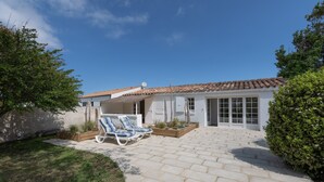 A house with a patio, two lounge chairs, a satellite dish, and a garden. - Le Temps des Vacances - À 500 m de la plage (La Brée-les-Bains)