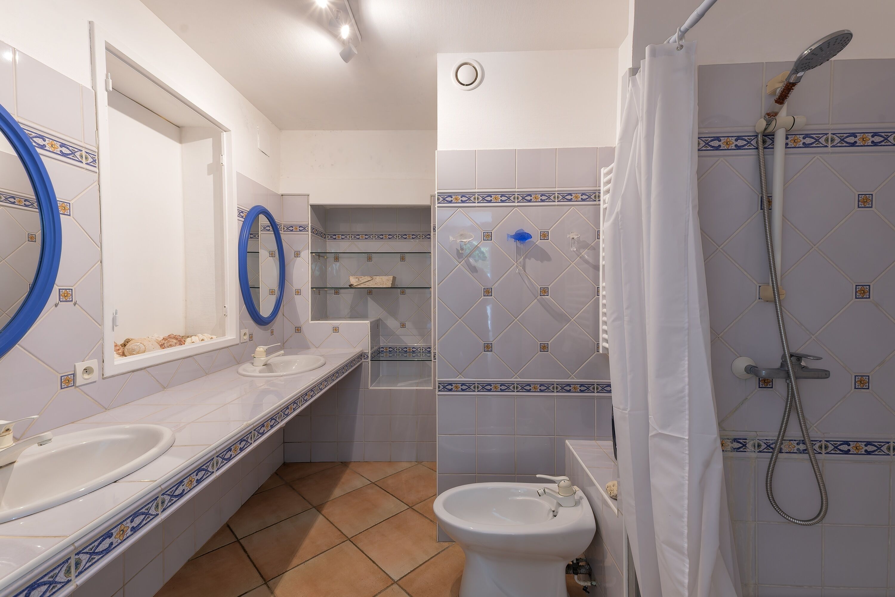 A bathroom with two sinks, a toilet, a shower, and a mirror.