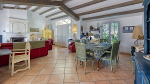 A spacious living room with a fireplace, dining area, and kitchen. - Le Temps des Vacances - À 500 m de la plage (La Brée-les-Bains)