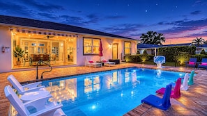 Ein Schwimmbecken mit Liegestühlen, einem Basketballkorb und einem Haus mit Terrasse.
