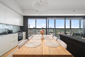 Una cocina moderna con comedor, ventanas amplias y vista a la ciudad.