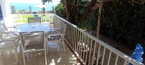 A patio with a round table and chairs, a white railing, and a view of the sea. - Villa María - Beautiful beachfront villa with private pool in Vinaròs - Ref 856 (Vinaròs)