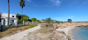 A coastal road with a gravel path, palm trees, and a beach. - Villa María - Beautiful beachfront villa with private pool in Vinaròs - Ref 856 (Vinaròs)