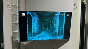 Een flatscreen televisie bevestigd aan een muur in een gang.