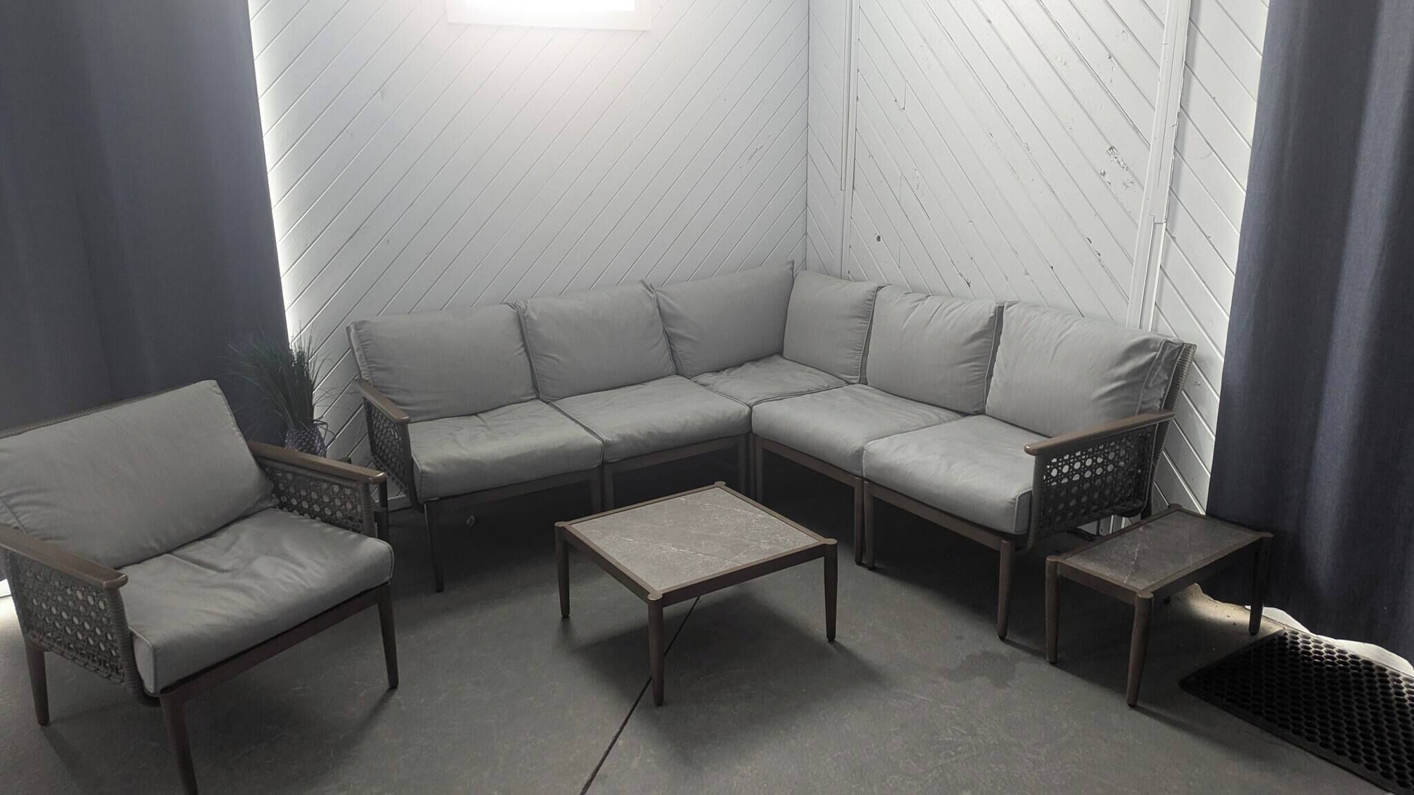Een zithoek met een bank, twee stoelen en een bijzettafeltje.