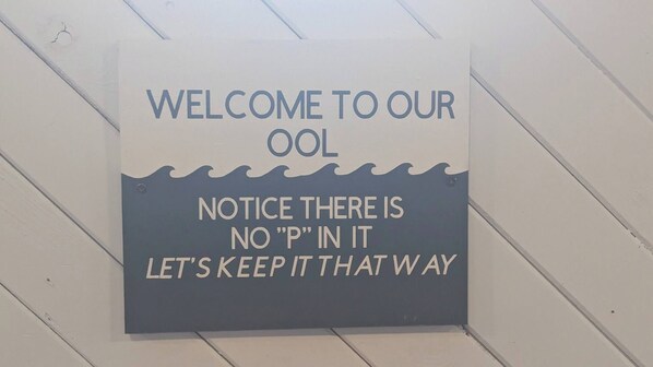 A sign with the text 'WELCOME TO OUR OOL' and 'NOTICE THERE IS NO 'P' IN IT LET'S KEEP IT THAT WAY'. - Indoor Pool! Hot Tub! Sauna! at the Blue Haven! (Trent Lakes)