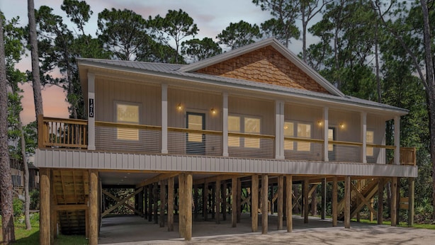 A two-story wooden structure with a covered porch, a staircase, and a view of the surrounding trees. - Luxury Retreat on Oleander - Unit I (Dauphin Island)