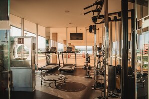 Ein Fitnessraum mit Laufbändern, einem Ergometer und Gewichten.