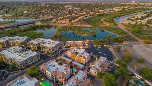 An aerial view of a residential area with multiple buildings, roads, and water bodies.