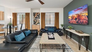 A modern living room with a sofa, coffee table, and a painting on the wall.