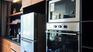 Eine moderne Küche mit integrierten Geräten, Holzschränken und einer schwarzen Arbeitsplatte.