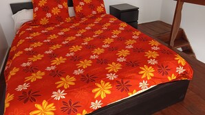 A bed with a floral bedspread, a nightstand, and a wooden headboard. - Studio 4 km from the sea swimming pool and garden Bicycle available for hiking (Villeneuve-lès-Maguelone)