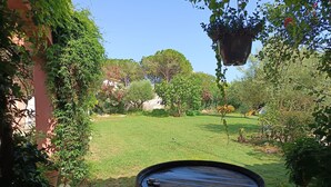 A garden with a barrel, potted plants, and a hanging planter. - Studio 4 km from the sea swimming pool and garden Bicycle available for hiking (Villeneuve-lès-Maguelone)