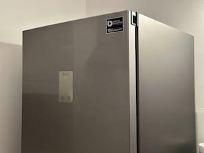 A stainless steel Samsung refrigerator with a 'No Frost' label and a '10 Warranty' sticker. - Quaint 2-bedroom apartment in the heart of Lublin (Lublin)