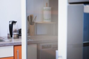 A kitchen with a coffee maker, a knife holder, and a dishwasher. - Quaint 2-bedroom apartment in the heart of Lublin (Lublin)