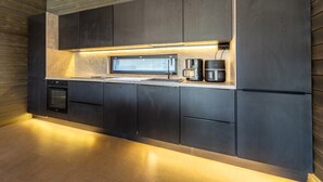 A modern kitchen with built-in appliances, a microwave, and a coffee maker.