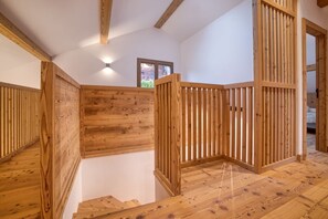 Ein Holzinnenraum mit Treppe, Holzwänden und einem kleinen Fenster.