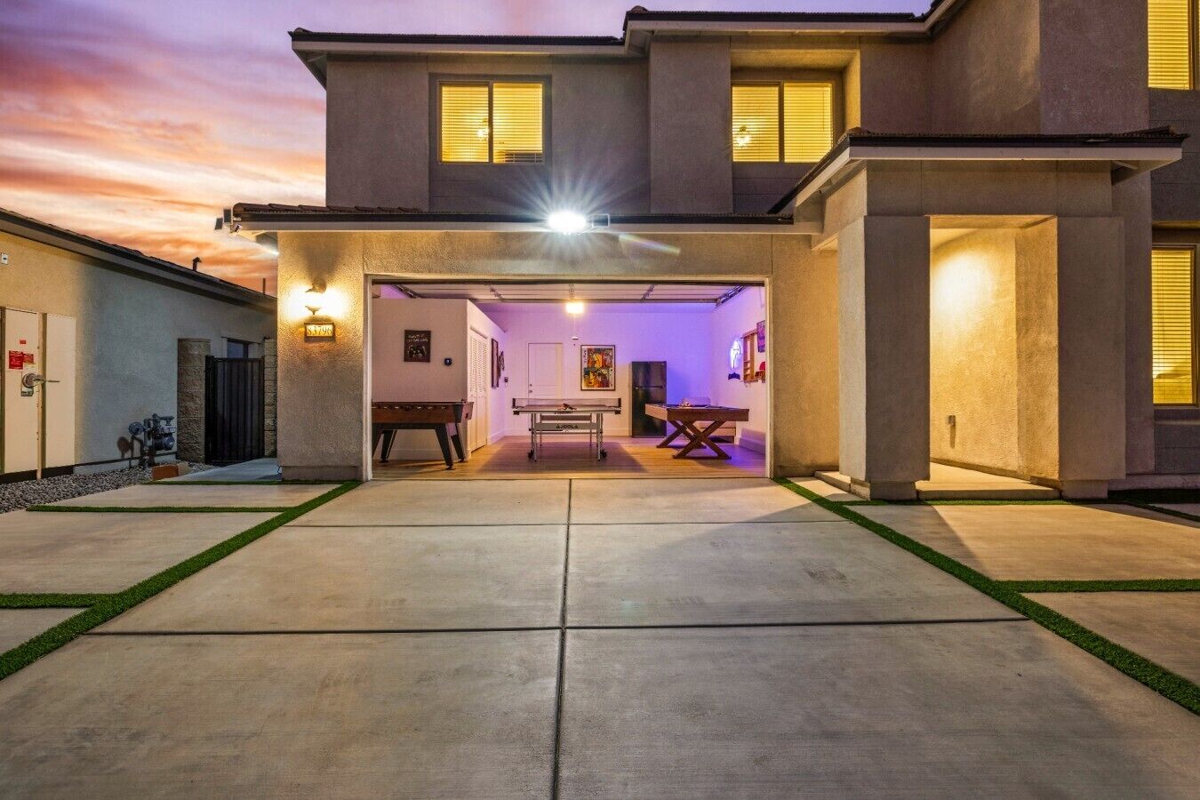 A residential building with a covered patio area, a pool, and a game table.