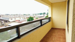 Ein Balkon mit Blick auf Gebäude und einem Fliesenboden.