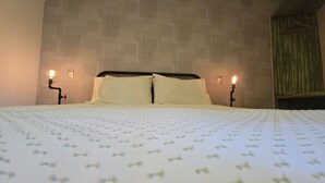 A hotel room with a large bed, two bedside lamps, and a wooden headboard. - Loft Il Rifugio di Fiammetta (Val'Quirico)