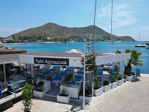 An Asia Restaurant with outdoor seating, a view of the sea, and a mountain in the background. - ASİA HOTEL (Bodrum)