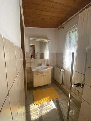 Ein Badezimmer mit Waschbecken, Spiegel und Dusche.