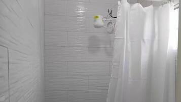 Een haardroger, handdoeken, zeep, toiletpapier