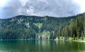A lake surrounded by dense forest and a mountain.