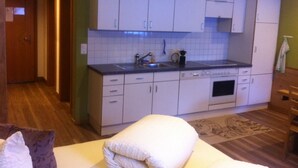 A compact kitchen with white cabinets, a sink, and a dishwasher. - Apart Bellezza, (Samnaun-Dorf) by Interhome (Samnaun)