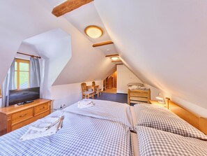A cozy attic bedroom with a loft bed, a desk, and a chair. - Penzion Exnar by Interhome (Strážné)