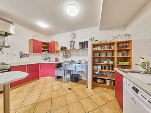 A kitchen with red cabinets, a sink, a stove, and a dishwasher. - Penzion Exnar by Interhome (Strážné)