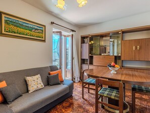 Ein modernes Wohnzimmer mit einem grauen Sofa, einem Holzesstisch und Stühlen.