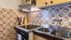 Una cucina con fornello, forno, lavello e mobili in legno.