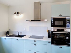 A modern kitchen with a Bosch microwave, oven, and a built-in range hood. - Dolce Vita by Interhome (Agon-Coutainville)